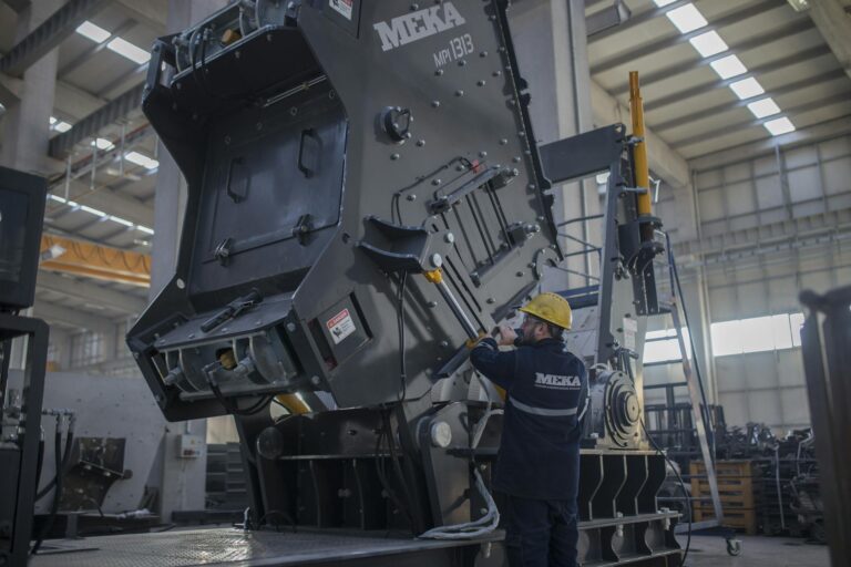 A worker in an Ankara industrial plant operating heavy machinery indoors.